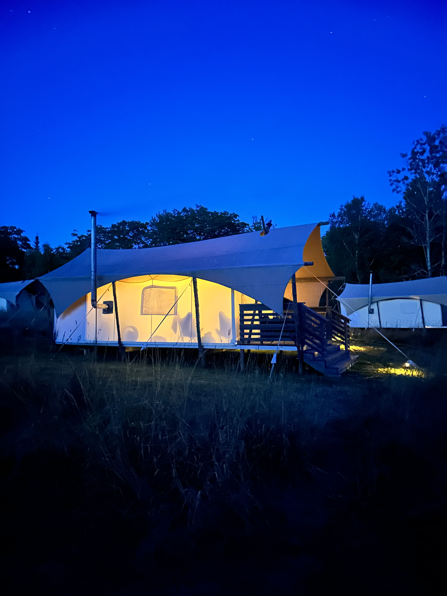 Under Canvas tents glowing in the evening light